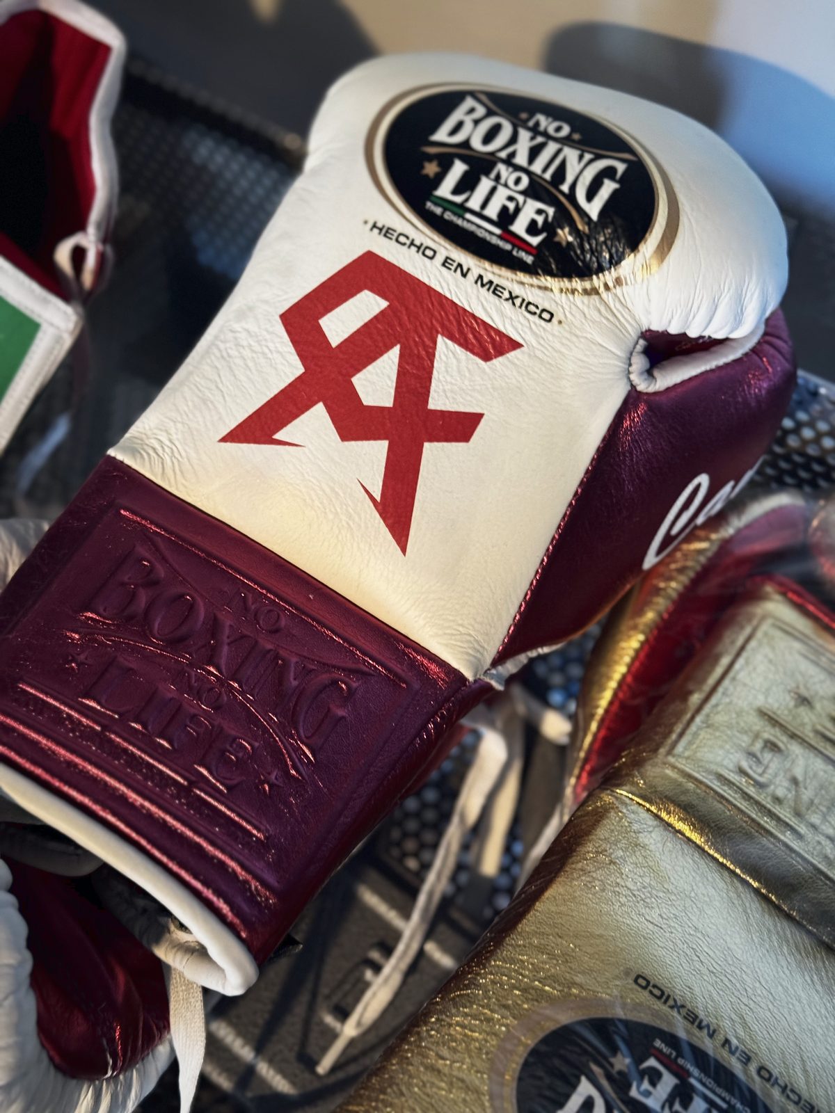 Close-up of a white No Boxing No Life glove with the red CA logo