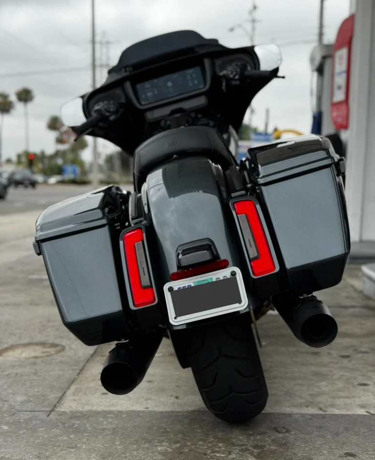 Low-angle rear shot highlighting the clean lines of the rear fender, stretched rear lights, and contoured saddlebags. The fairing, bars, and radio fade softly in the background—letting the rear-end styling speak for itself.